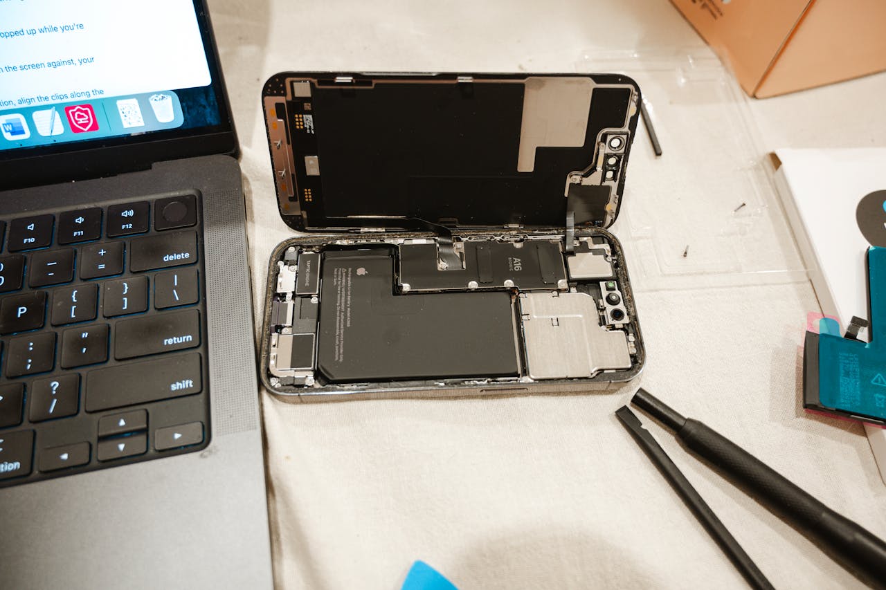 home-hero Open iPhone with repair tools and laptop, showcasing DIY battery replacement process.